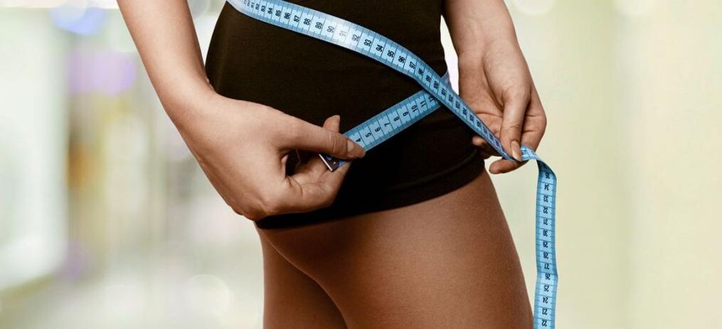 Жінка фіксує результати ефективного позбавлення від зайвої ваги. 